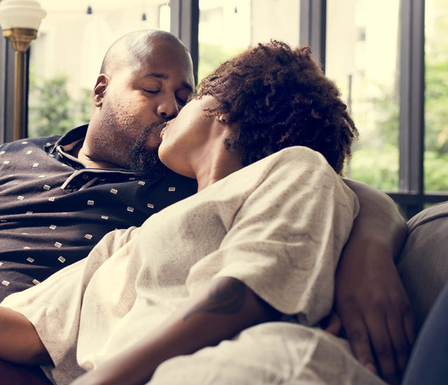 Black couple kissing on the couch