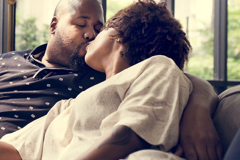 Black couple kissing on the couch